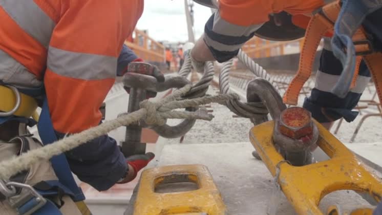 Video: Slow-motion view of people tying a metallic rigging A slow ...